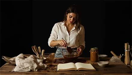 Natália trabalhando chocolate em bancada rústica